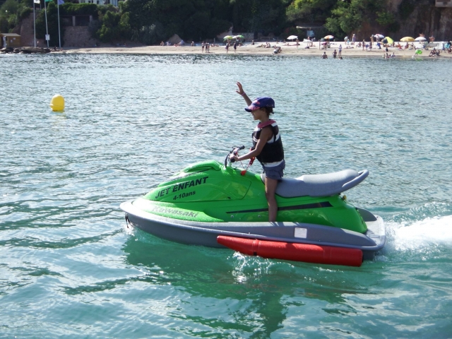 Criança de forma independente em seu jet ski elétrico 