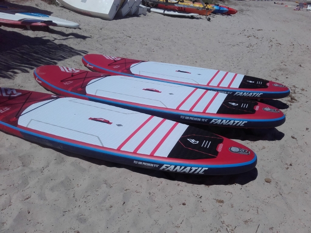  Three Stand Up Paddle boards placed on the sand 