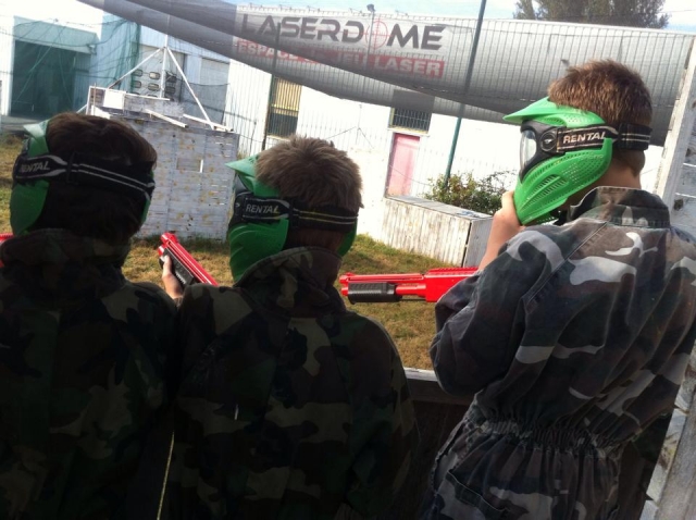  Tre bambini di spalle attrezzati per giocare a paintball 