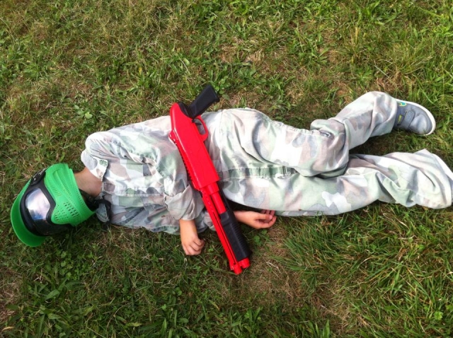  Bambino a terra che gioca a paintball 
