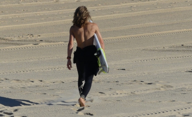  Surfer spaziert an der Küste entlang 