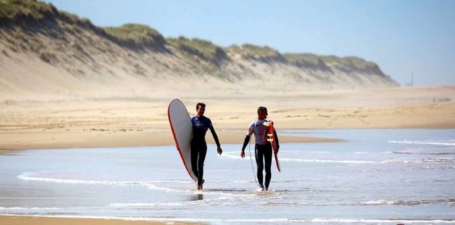  Zwei Surfer gehen am Strand spazieren 