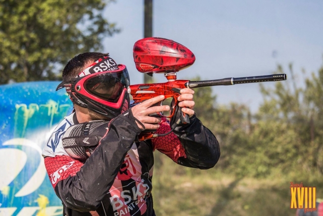 Ein Paintballspieler mit einer roten Waffe.