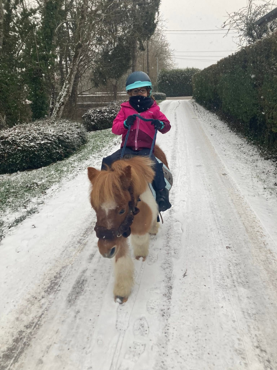  A child on a pony in the snow 
